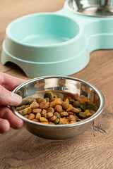 bowl for cat food on a wooden background. double bowl for water and cat food