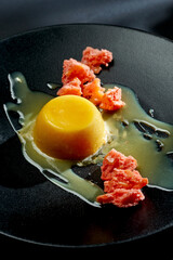 Italian panna cotta with caramel and biscuit in a plate on bright backgrounds. Selective focus, hard shadows