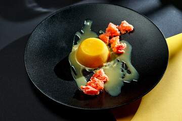 Italian panna cotta with caramel and biscuit in a plate on bright backgrounds. Selective focus, hard shadows