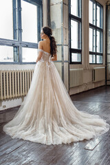 bride in white wedding dress at the window in loft studio
