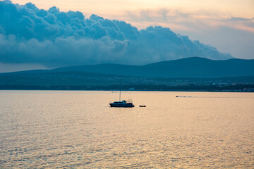 Obraz premium a modern yacht at sea at sunset. the sky is gradually becoming overcast.