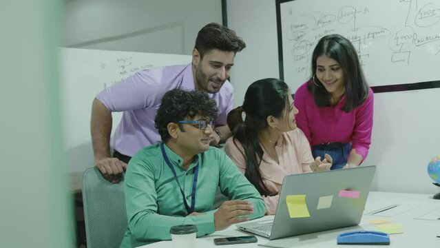 Group of Indian friends making a video call on laptop and talking with fun and smile face together.diverse happy young Asian people having fun a great time and looking at camera.lifestyle concept.
