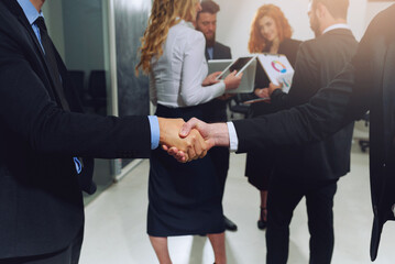 Handshaking of business person in office as teamwork and partnership
