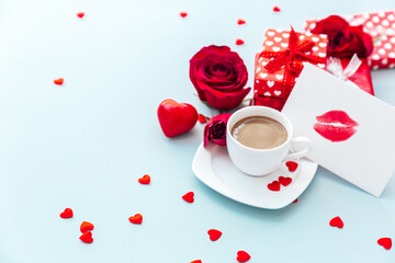 Valentine day composition with coffee cup, rose flower and gift box on table. Top view, flat lay. Holiday concept.