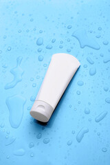 tube of cream on a blue background with drops