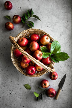 A basket of whole red apples with a paring knife.