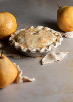 Pear pie process shot on neutral background, with homemade pastry