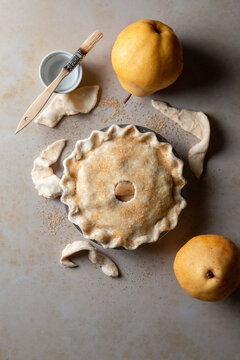 Pear pie process shot on neutral background, with homemade pastry