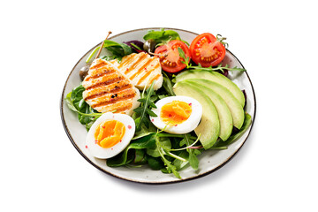 Healthy keto diet breakfast: boiled egg, avocado slices, grilled halloumi cheese, salad leaves. Isolated on white background.