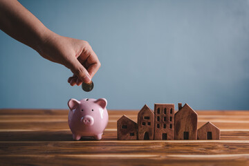 Money Savings for Future Property House Concept, Hand is Putting Coin Into Piggy Bank for Saving Future Housing Real Estate Ownership. Banking Fund for Investing House Asset and Real Estate