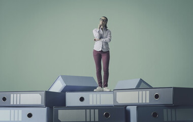 Fototapeta premium Businesswoman standing on a load of messy ring binders