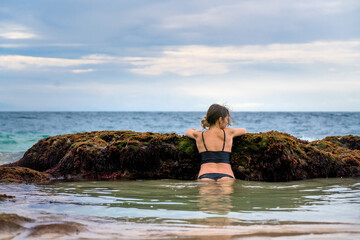 Fototapeta na wymiar Woman looking to ocean on Secret Jimbaran beach, Bali, Indonesia