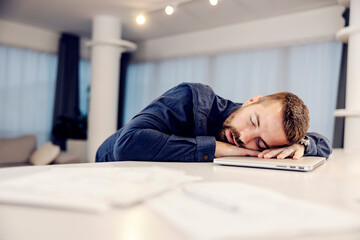 Obraz premium An exhausted entrepreneur sleeping on his laptop at home. 