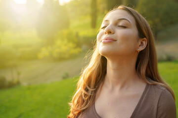 Fototapeta na wymiar Close-up woman at sunset relaxing breathing fresh air