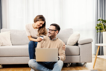 A happy couple at home trying out new credit card for online purchase.
