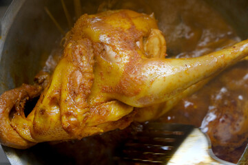 Whole roasted golden crispy chicken in a skillet cooked with lemongrass spice in a frying pan