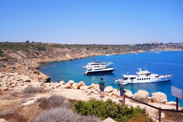 Cyprus coastal bay with people watching yachts