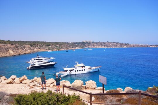 Cyprus coastal bay with people watching yachts