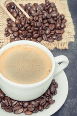 Coffee in cup and roasted dark coffee beans