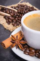 Coffee in cup and roasted dark coffee beans with anise and cinnamon