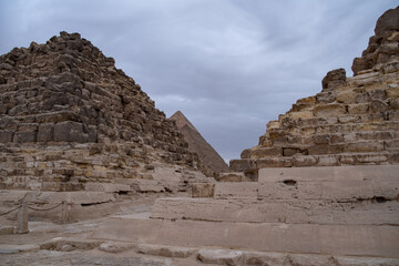 Fototapeta na wymiar Ruins of the small pyramid of Queen Henutsen with Khafre Pyramids at background, Giza Plateau, Egypt. UNESCO World Heritage