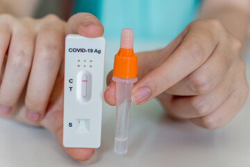 Hands holding Covid-19 rapid antigen test kit ready to use. Tube and test cassette with specimen