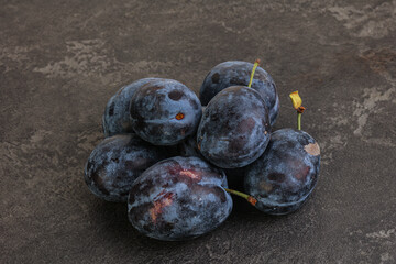 Ripe plum heap over background