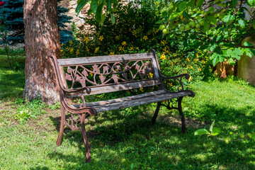 Banc ancien rouillé à l'ombre d'un arbre dans une petite coure d'un vieux village du puy de dôme