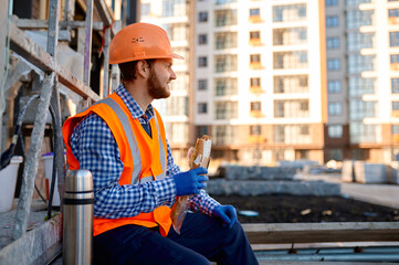 Construction worker eating sandwich during lunch break