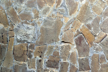 Wall made of natural stone, different shapes and sizes, brown