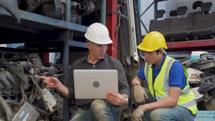 Foreman and worker is checking used car parts in a warehouse on a hot day. Foreman are working in heavy industrial plant engine parts factory. - Powered by Adobe