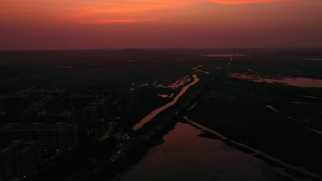Vehicles Driving In The Road At Night With Red Sky In Vasai Mumbai, India. - aerial