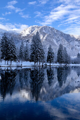 reflection of the mountains of the shore and the forest in the mountain lake