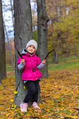 Happy little girl in the park. Autumn season.