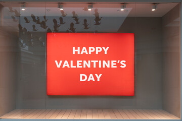 Happy valentine's day - red billboard in the advertising window of a boutique store behind glass