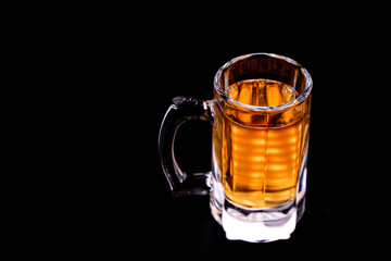glass mug with beer without foam on a black background. copy space. low-alcohol drink. brewery. soft drink.
