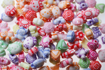 Fototapeta na wymiar Pile of cute colorful ceramic beads on white background, closeup