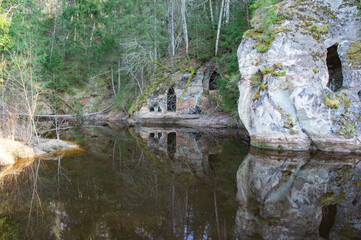 reflections of caves in the rocks near a river