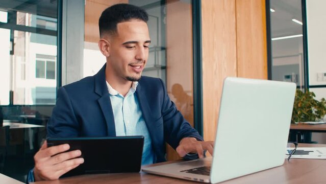 4k video footage of a businessman using a digital tablet and laptop in an office