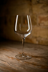 empty wine glass on a high leg on brown background