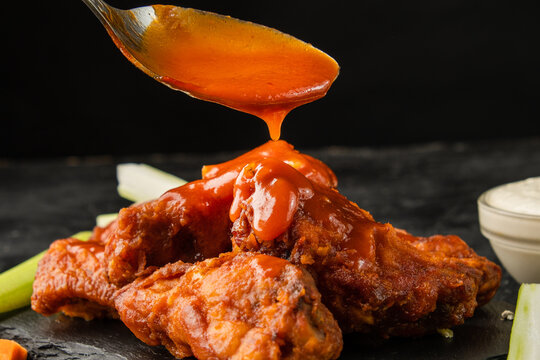 Classic buffalo wings topped with sauce. BBQ wings.