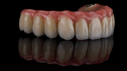 macro photo of a dental prosthesis of the upper jaw on a black background with excellent reflection