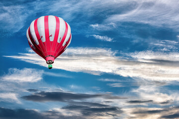 Fototapeta premium A hot air balloon in the sky on the background of bright sunset.