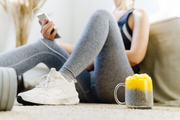 Close Up Of Woman Using smartphone To Count Calories For Post Workout Chia Pudding.