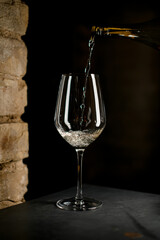 Elegant crystal champagne flute on high stem filling with sparkling champagne
