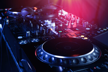Fototapeta na wymiar Closeup view of modern DJ controller with headphones on color background