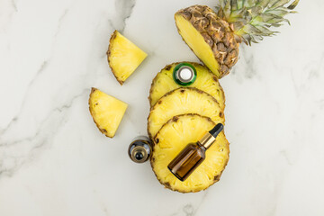 top view of the chopped juicy ripe pineapple with various cosmetic bottles with natural self-care product.