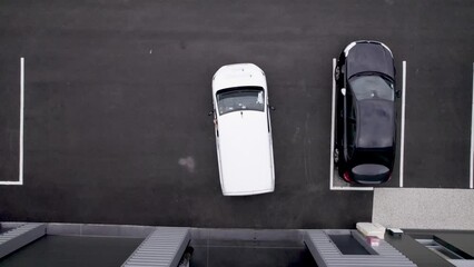 White work minivan leaving a warehouse seen from above, Aerial top view follow shot