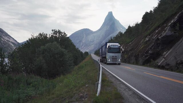 Truck Driving Through Road Overlooking Stetinden Mountain In Norway - wide shot