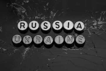 The word Russia and Ukraine on the background of broken glass.
